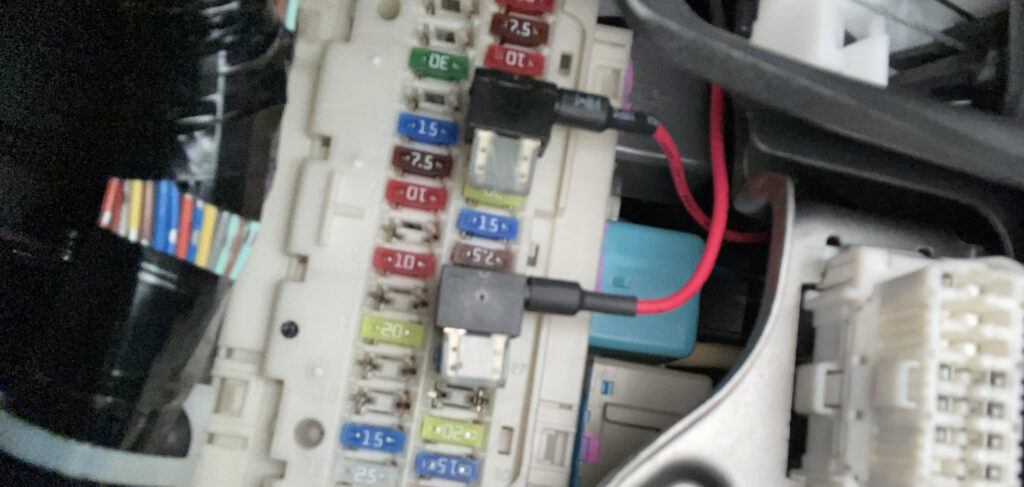 Picture of Add-a-circuit fuse taps installedd into the passenger cabin fuse box of a car.