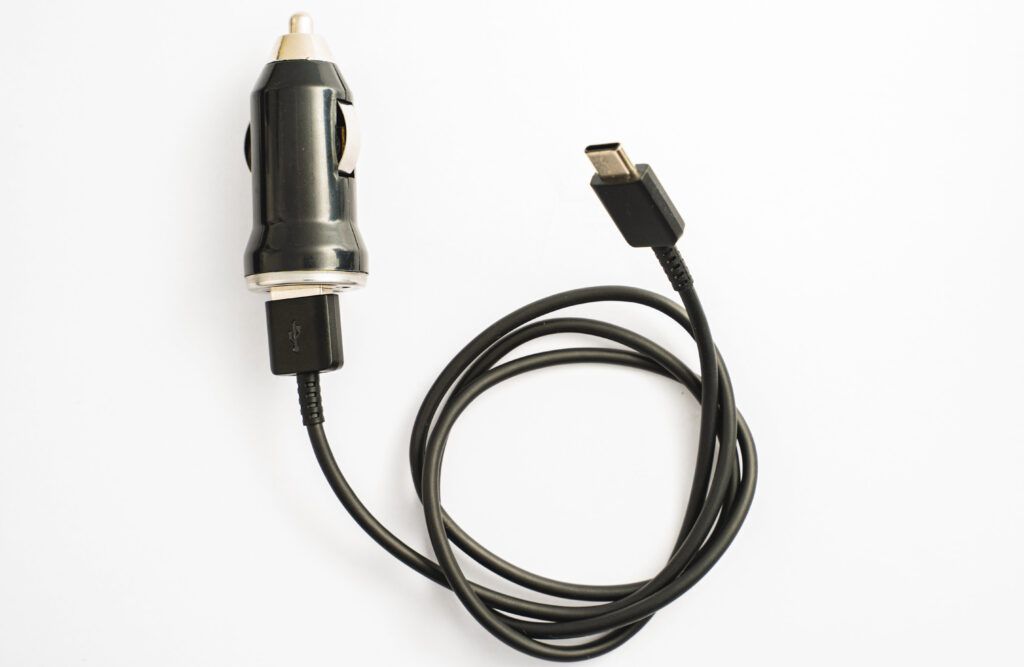 Black car charger with attached USB cable on a white background