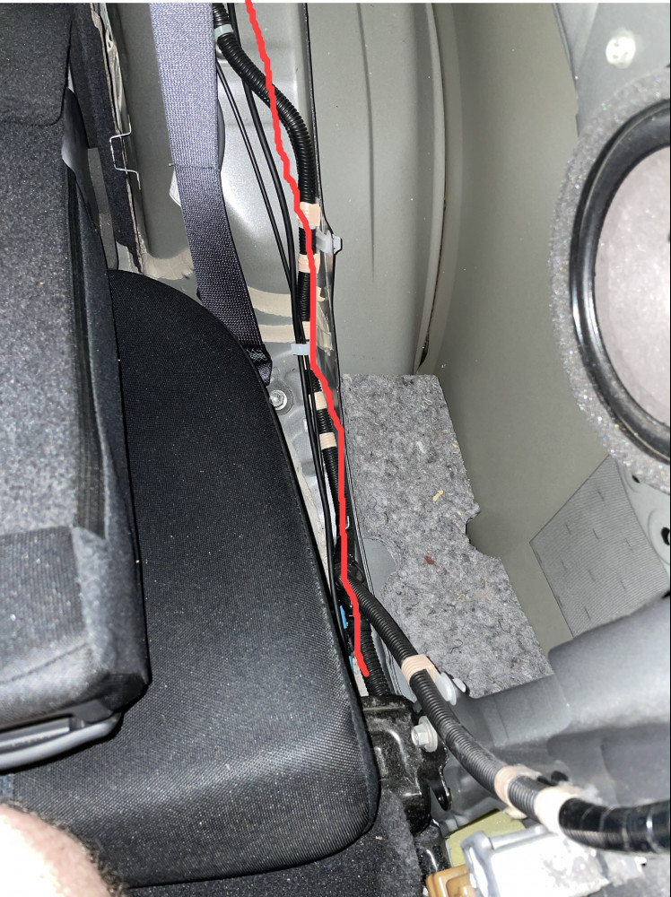 Rear dash cam cable passing next to rear driver's side passenger seat and over the rear wheel well.