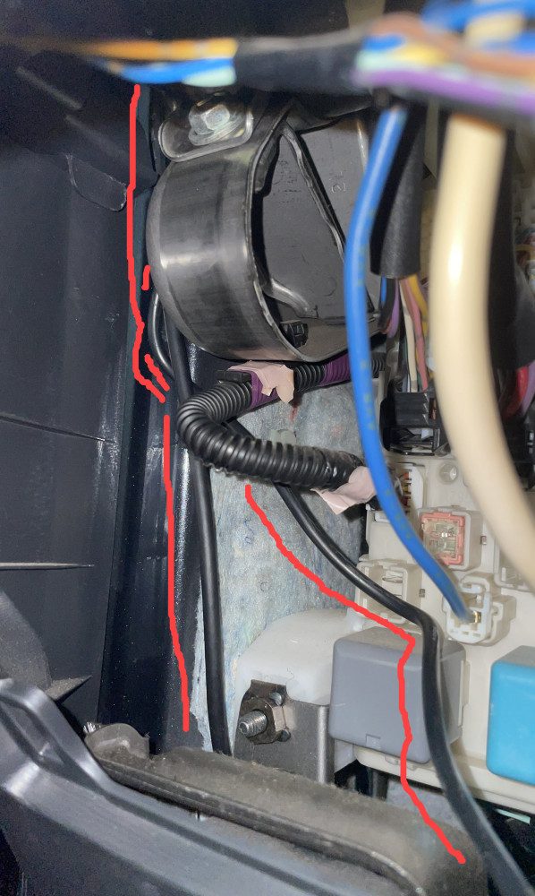 Two black dash cam cables inside the passenger cabin fuse box.